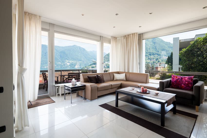 Room with quartz floor tiles, couch, sofa chair and white curtains