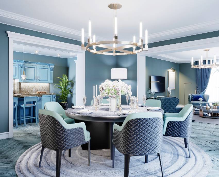 A luxurious dining room in blue, white and black color with candle chandeliers, a large round served table and chairs