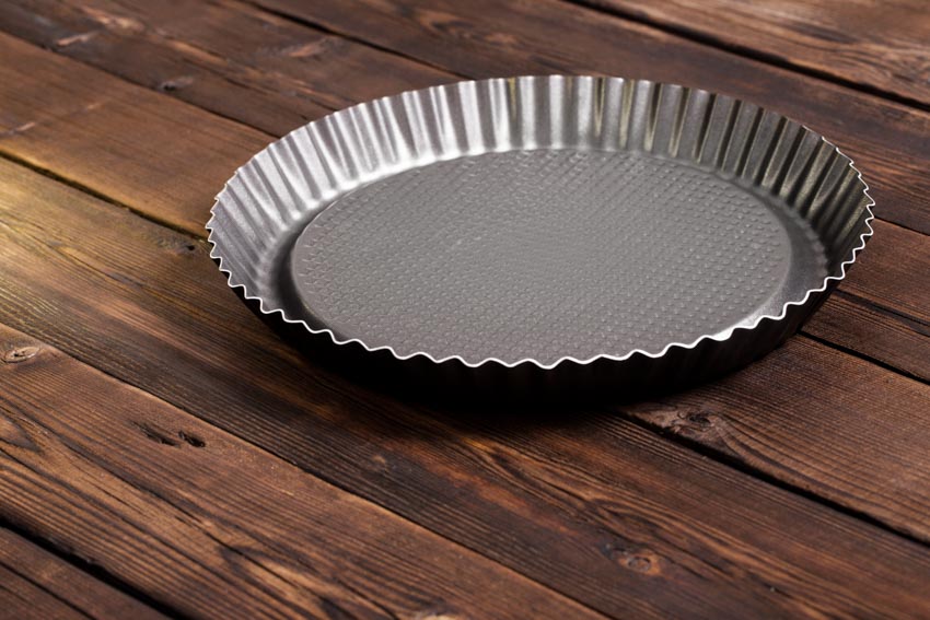 Metal pie plate on top of wood surface