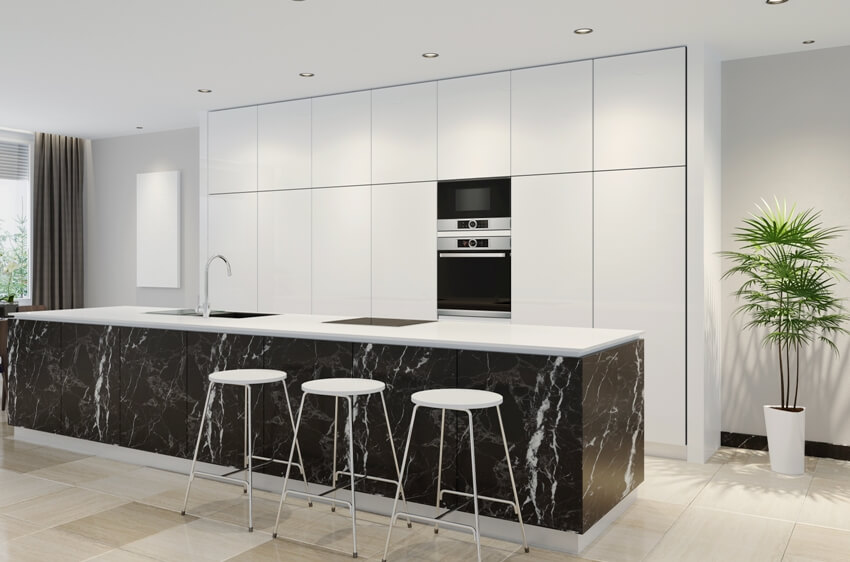 Kitchen with marble island, white stools and cabinets with built in oven 