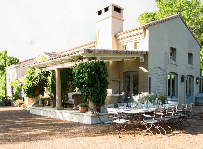 Outdoor area with decomposed granite patio, chairs, table, deck, canopy roof, and potted plants