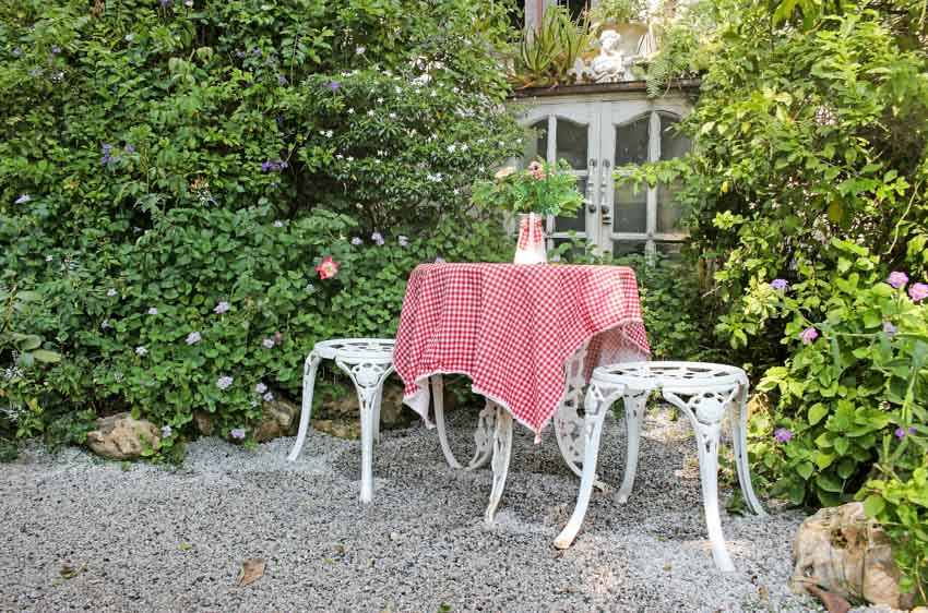 Outdoor relaxing spot with crushed granite, stools, and table
