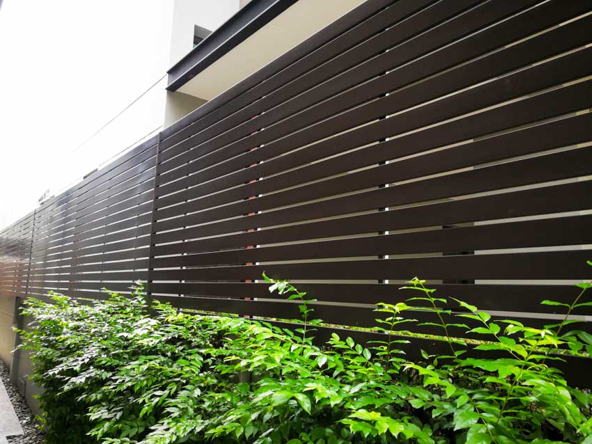 Outdoor area with horizontal staggered fence, and hedge plants
