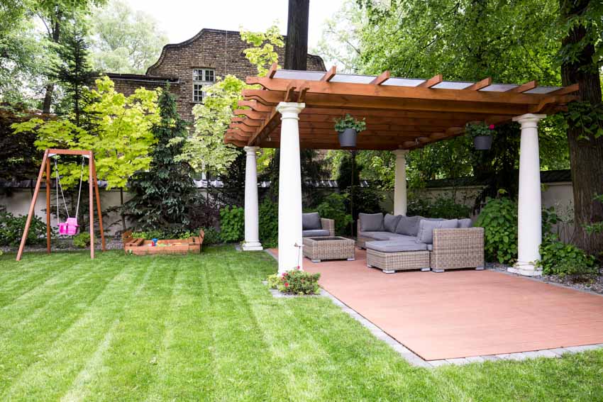 Outdoor area with pergola, hedge plants, trees, and outdoor furniture