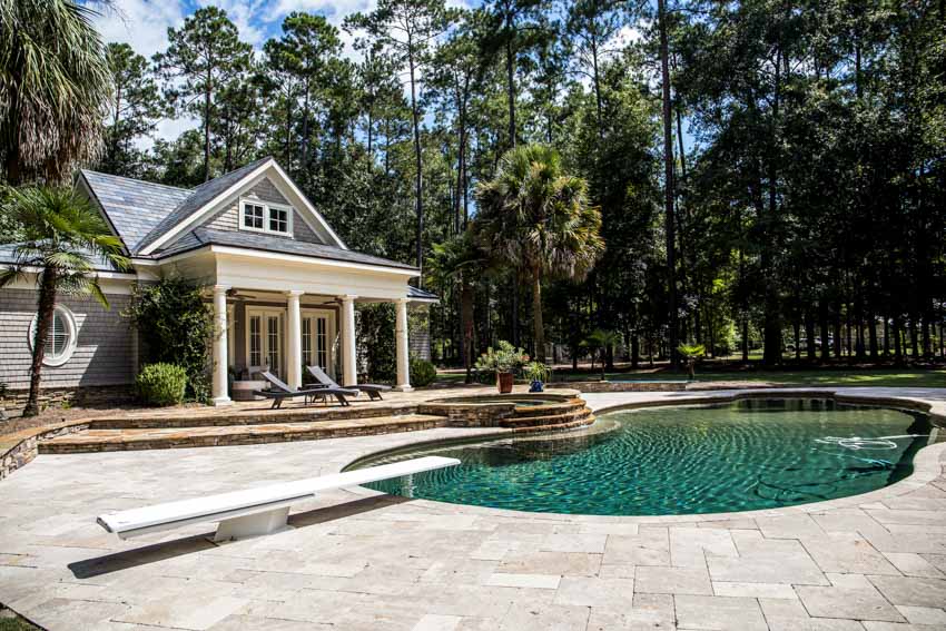 Outdoor area with porch, lounge chairs, swimming pool, and gray limestone pool deck