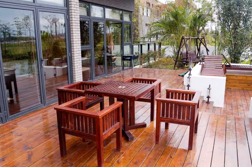 Deck made of planks of redwood with outdoor furniture and glass doors