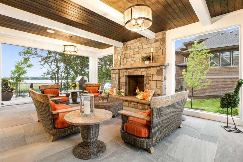 Outdoor patio with beadboard ceiling, fireplace, side table, chairs, and sofa