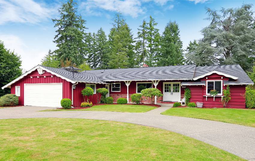 A red ranch with garage and wide front lawn with pathway