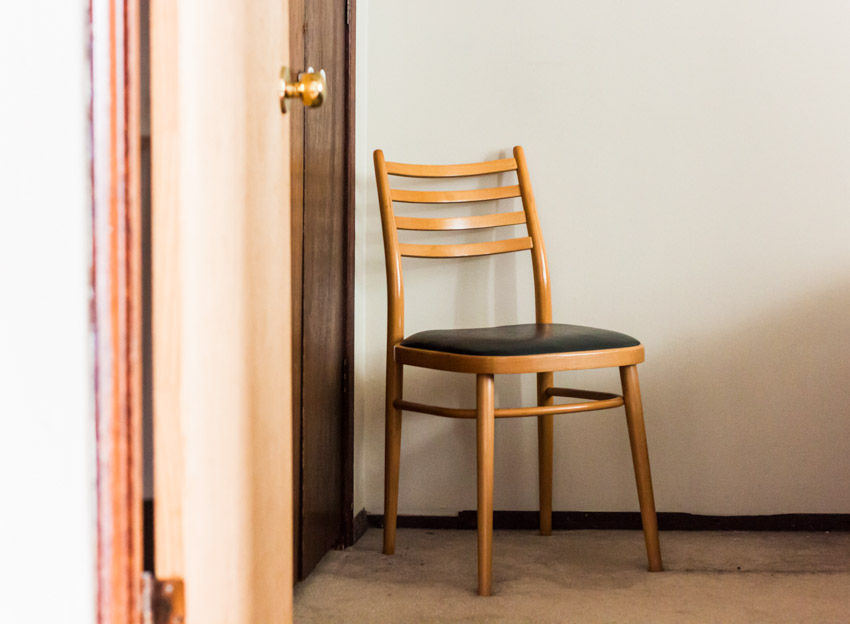 Room with side chair, cushioned seat, and door