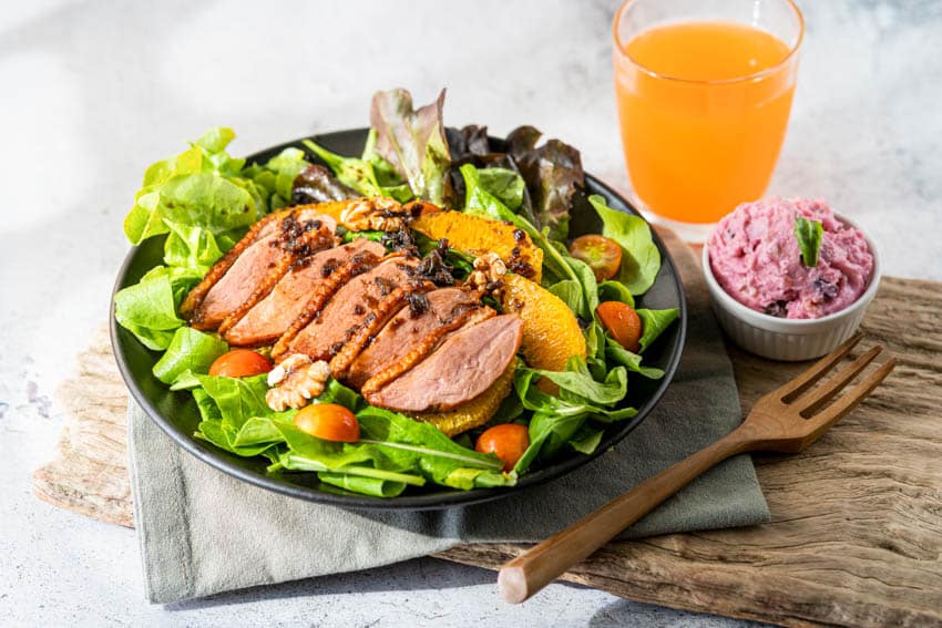 Plate with salad greens, chicken cutlets and a bowl of ice cream