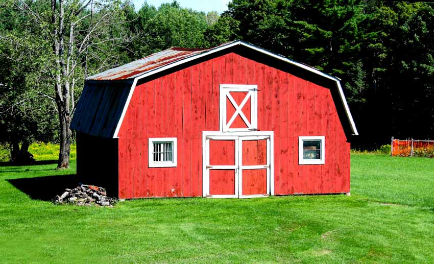 Small white and red barn with door and windows