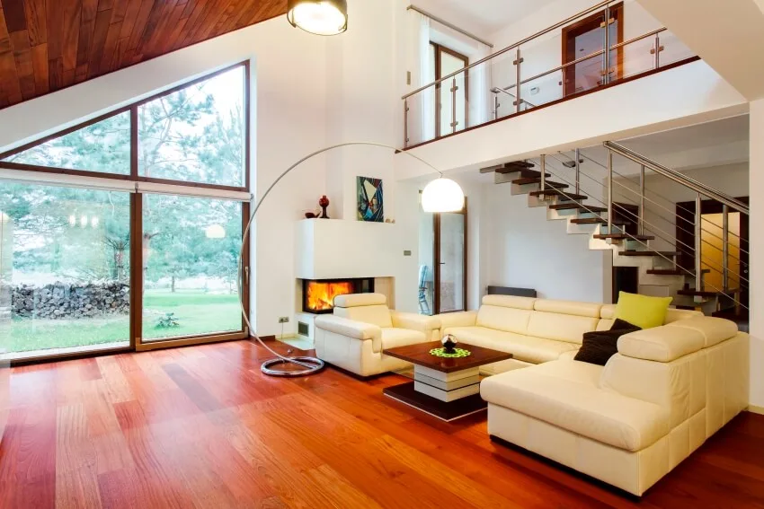 Room with white sofa, center table, floor lamp and big glass windows 