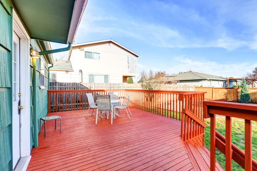 Spacious outdoor area with redwood deck, table, chairs, and wood railings