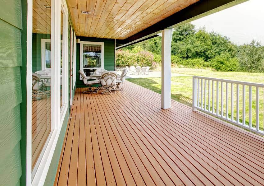 Spacious teak wood decking with patio table set and backyard view