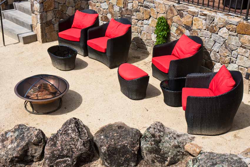 Stabilized granite sitting area with cushioned barrel chairs, and landscaping rocks