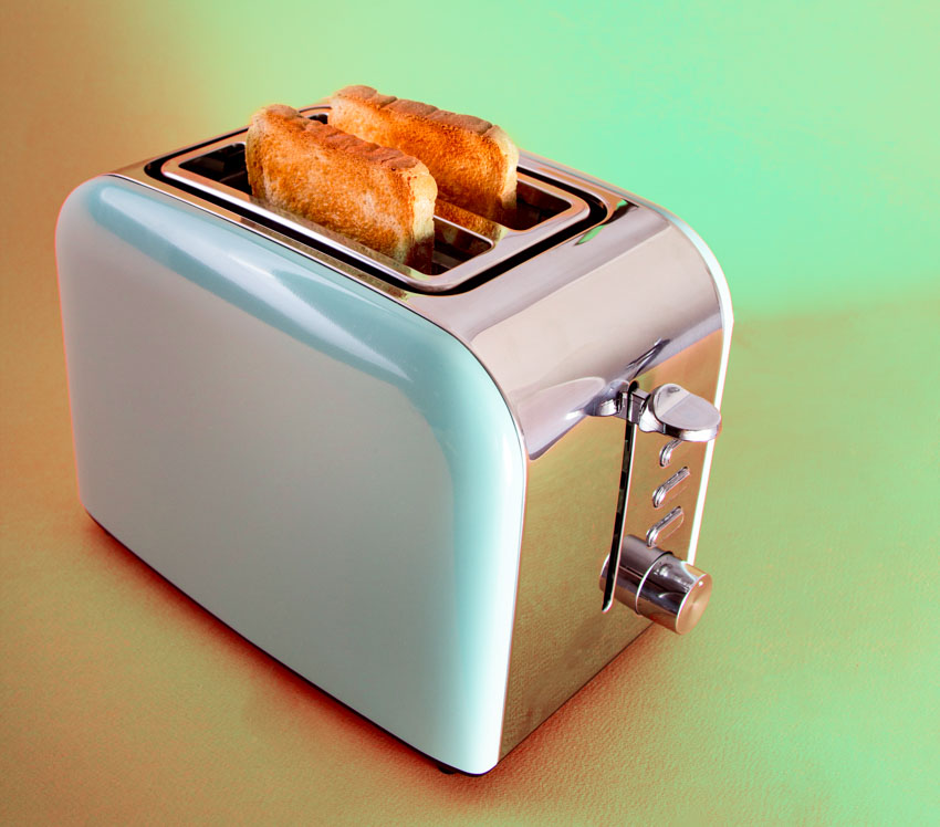 Standard toaster made of metal with bread in it is