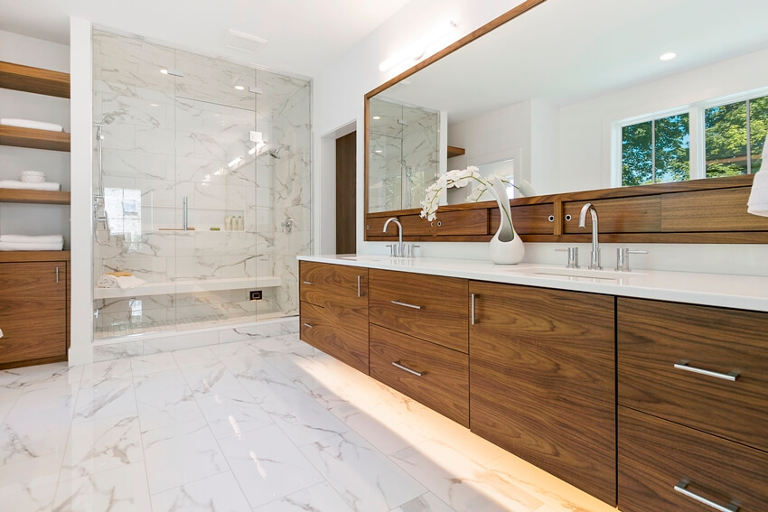 Stunning bathroom interior with wooden drawers, large vanity mirror, and large format quartz tile floors and walls
