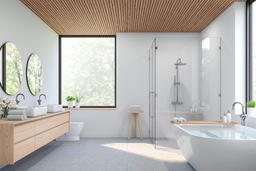 Stunning bathroom with glass window, counter with two sinks and round mirror