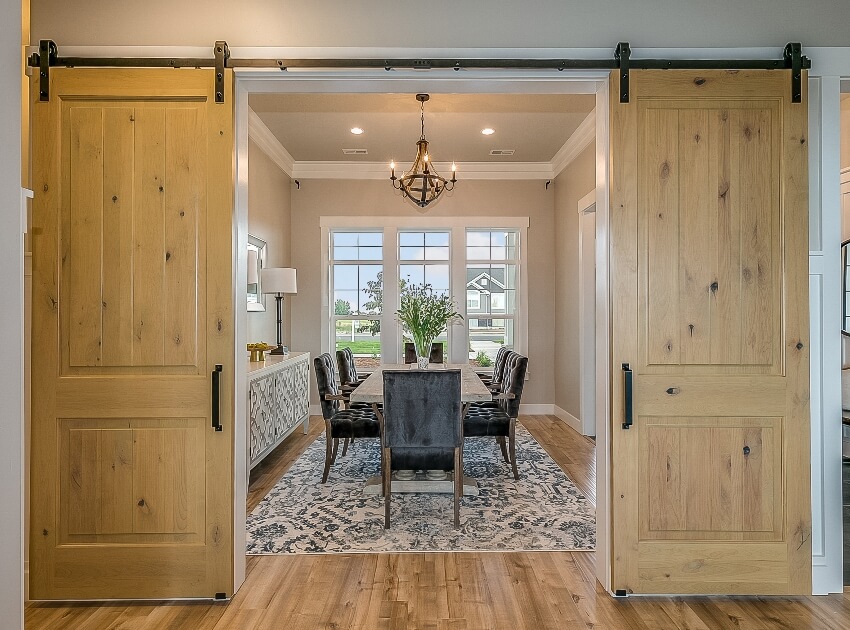 Stunning wooden interior with double barn door entrance to dining area