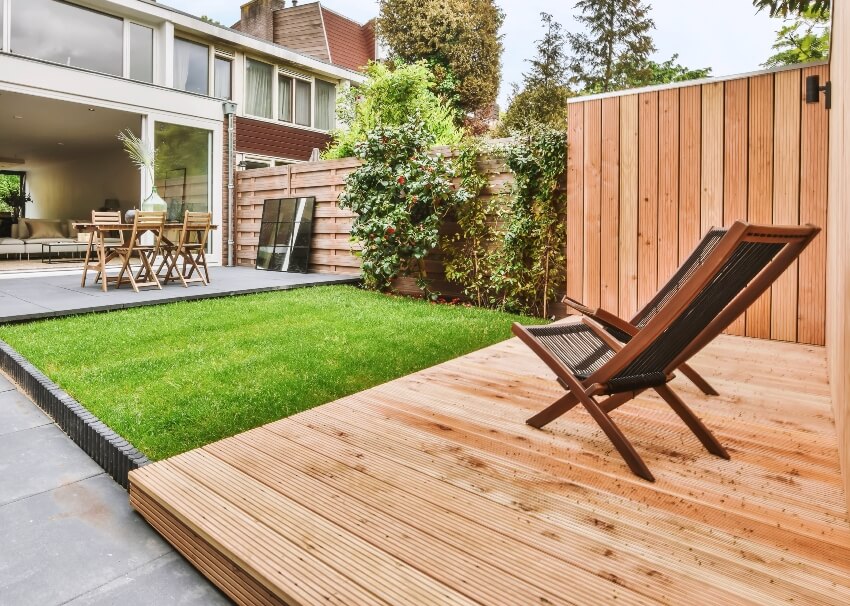 Stylish and well maintained courtyard of the house with tongue and groove Douglas fir deck, wooden table and chairs and a fresh lawn