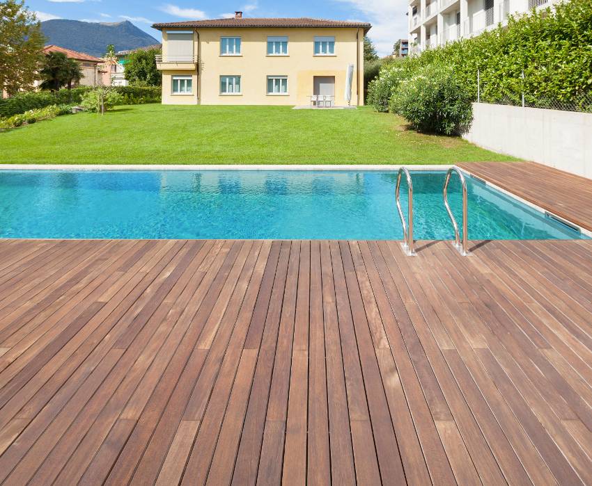 Swimming pool on backyard with teak wood decking of a private residence