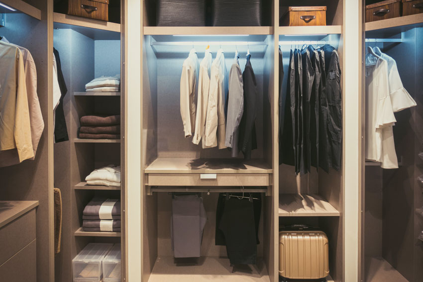 Walk-in closet with hangers lighting fixtures and shelves