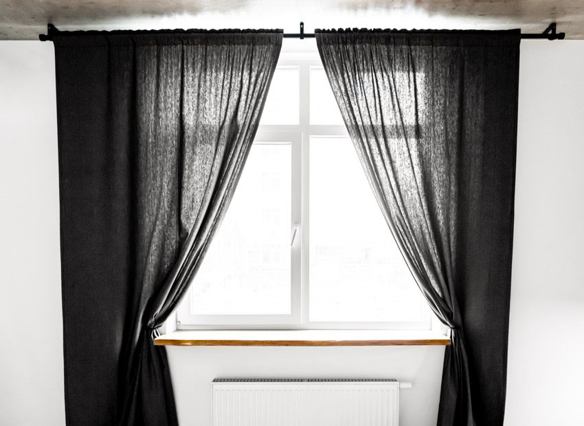 Window with black curtain and ceiling curtain rod