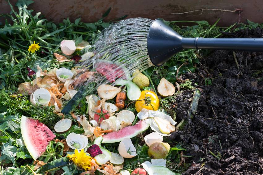 Watering compost box full with garden browns and greens and food wastes