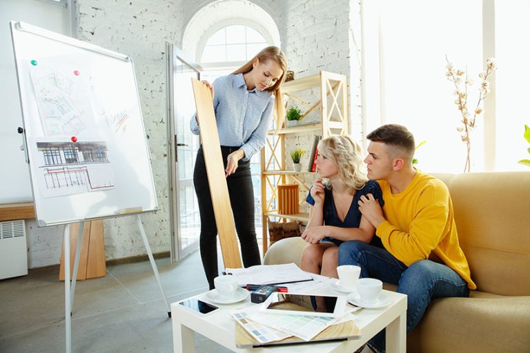 Interior Designer Working With Couple Presenting Vinyl Tile Planks With Architectural Sketch On Easel Is 768x512 
