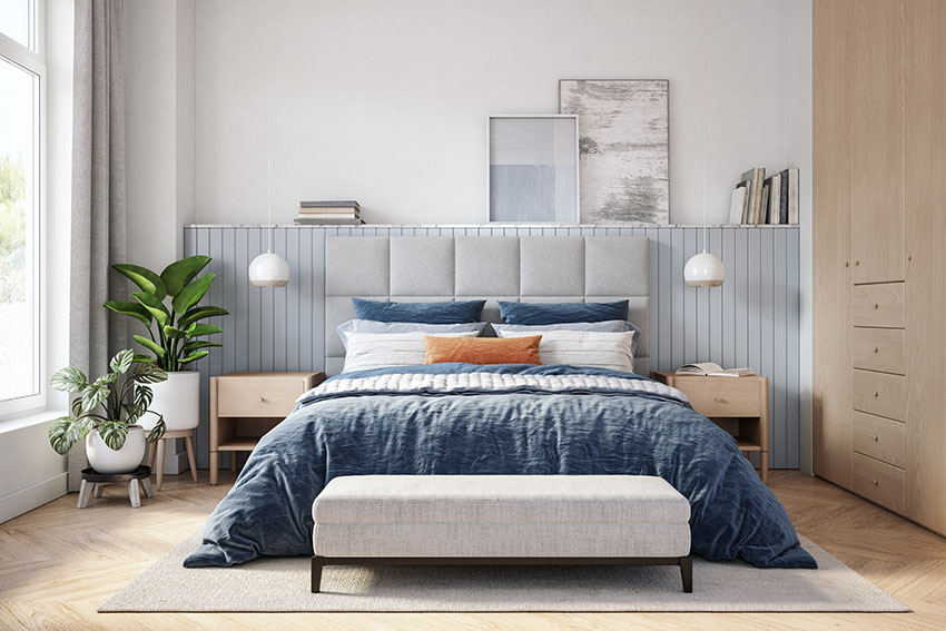 Scandinavian style bedroom with bedside table blue bed sheet and pillows indoor plants bed bench
