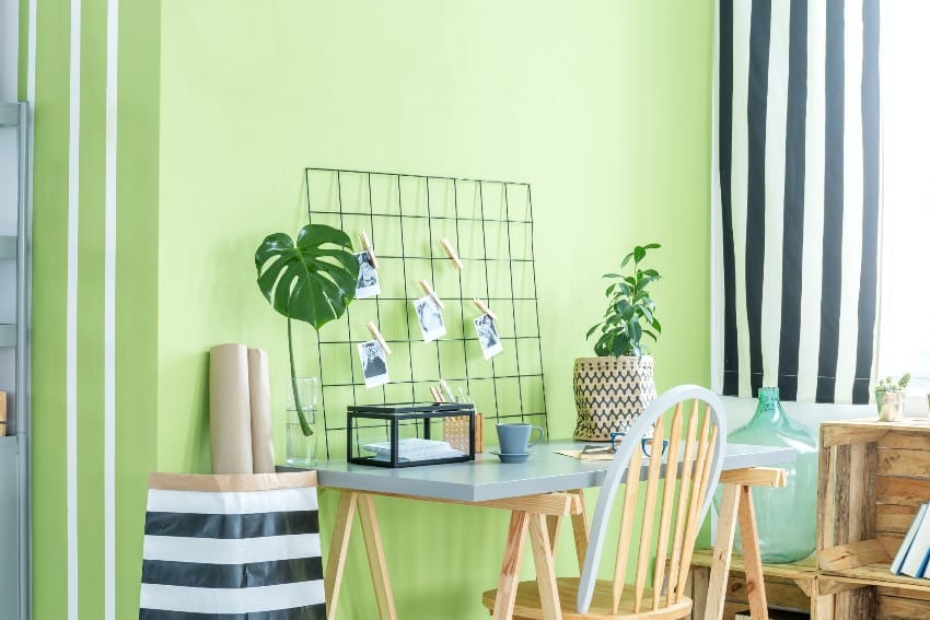 Aesthetic working area with lime green walls, wooden accents desk and a chairs