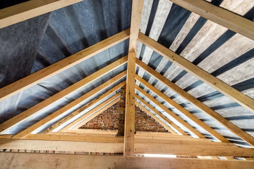 Attic with angled wooden beams and metal panels