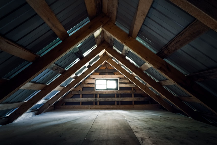 Attic crawl space with wooden beams and small window