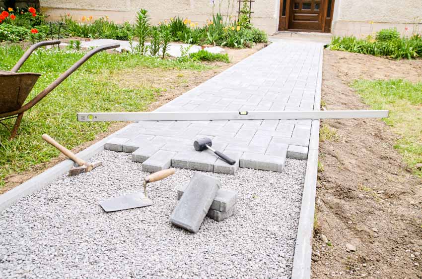 Backyard area with fresh paver, grass and hedge plants