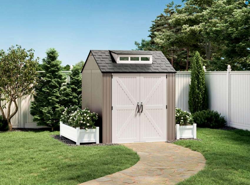 Backyard with storage shed, white fence, and plants