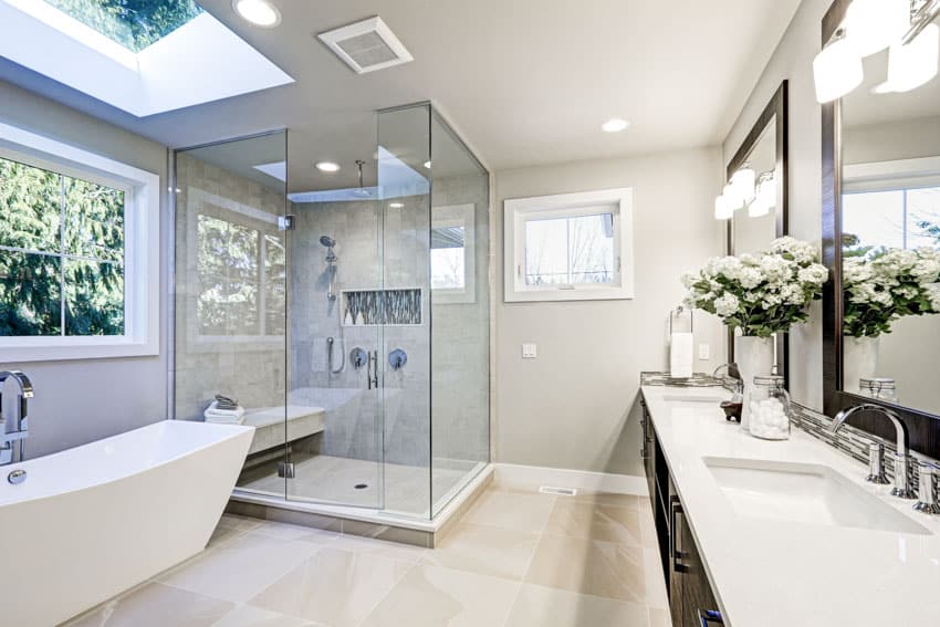 Bathroom with hinged shower door, glass enclosure, tub, vanity, countertop, mirror, window, and skylight