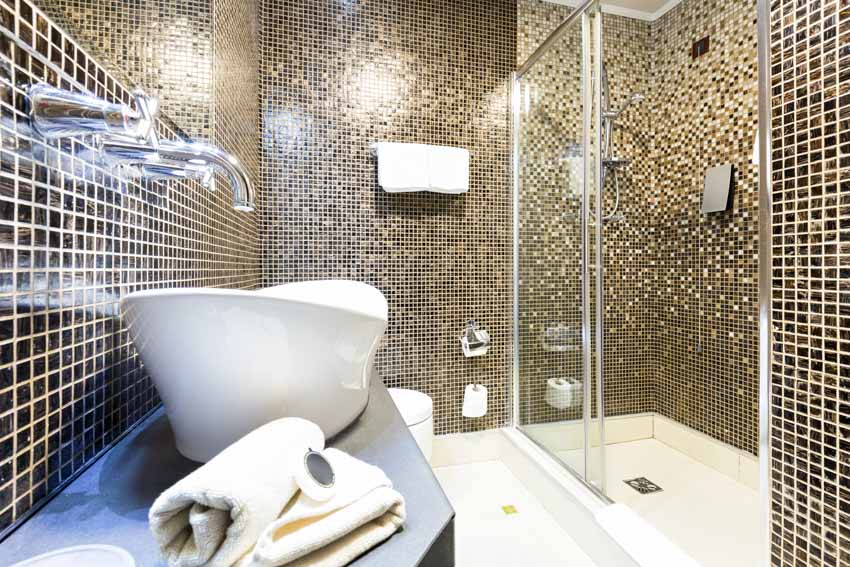 Bathroom with sink, faucet, shower enclosure, and mosaic tile shower wall