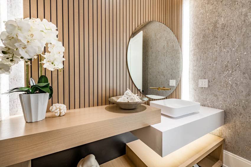 Bathroom with slat wall system, mirror, sink, floating vanity, and accent lighting