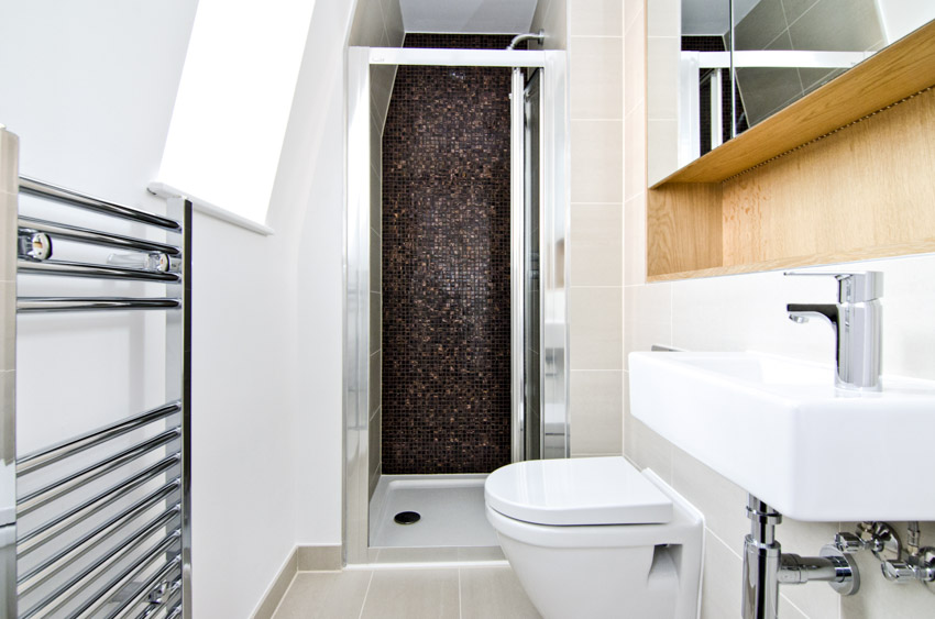 Bathroom with rack for towels, pedestal basin and white walls