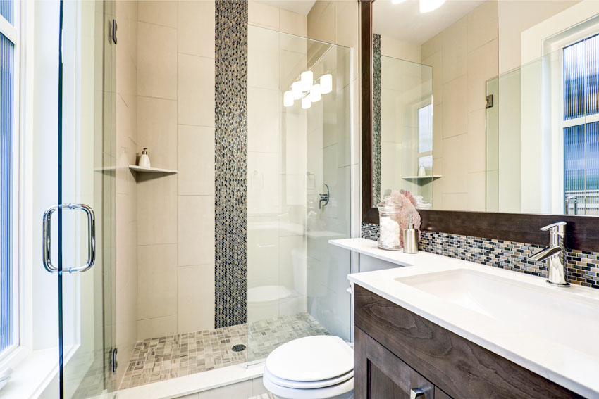 Bathroom with waterfall shower wall, toilet, window and backsplash