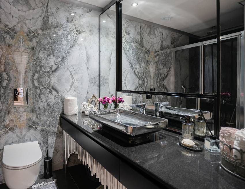 A beautiful dark marble bathroom design with modern fixtures and black galaxy granite countertop