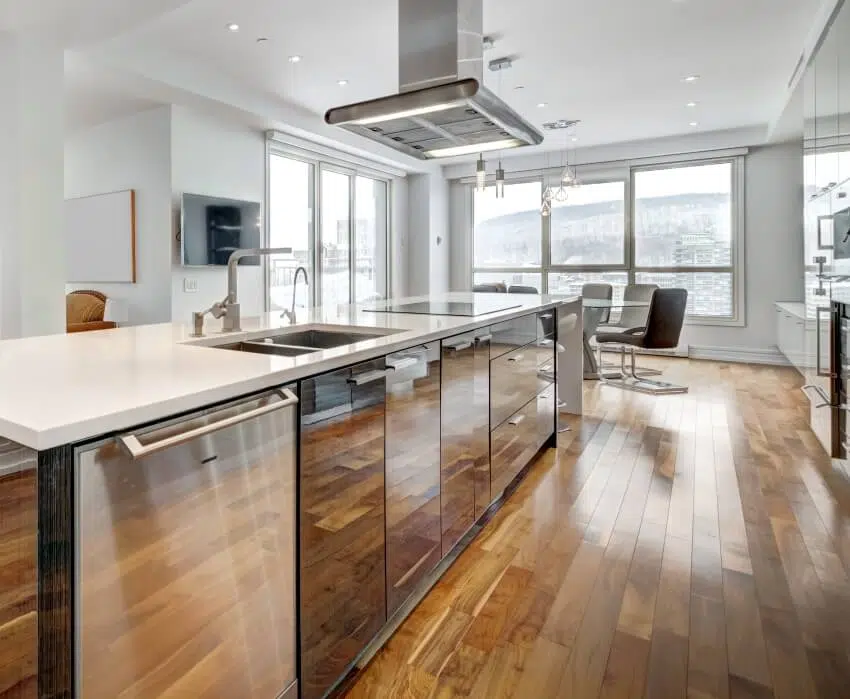 Beautiful kitchen with natural lighting, hardwood floors, mirrored cabinet and drawers with quartz countertop