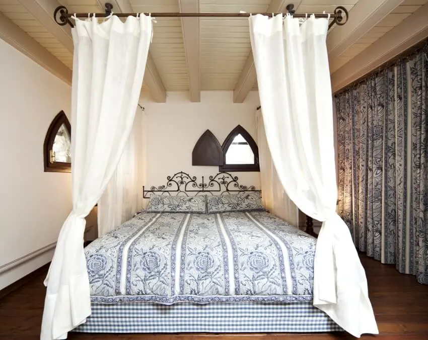 Bedroom with ceiling bed canopy and same designs of bedsheet and curtains