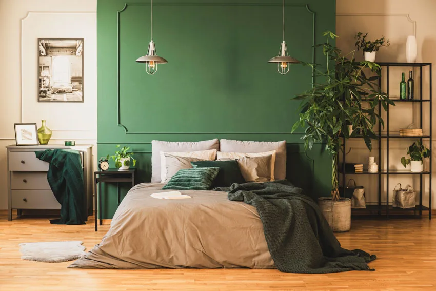 Bedroom with bed, nightstands, green accent wall and dresser table
