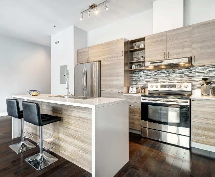 Bright and beautifully designed kitchen with grade a teak cabinets, stainless steal appliances and island with black chairs