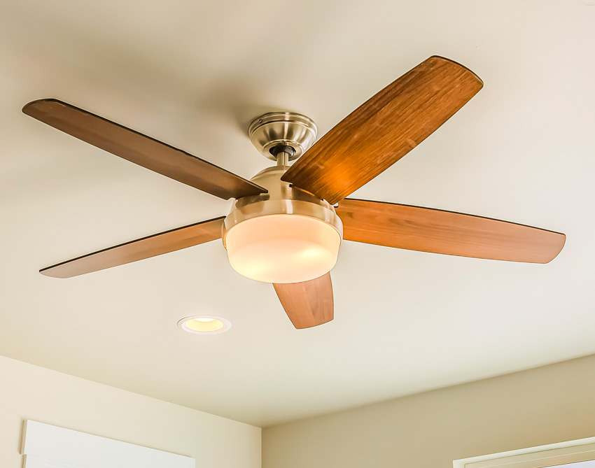 Ceiling fan for home interiors with wood blades and light bulb