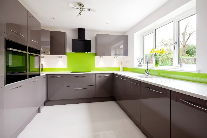 Contemporary fitted kitchen in striking lime green grey and white color scheme with built in appliances, white granite countertops, dual ovens and hob