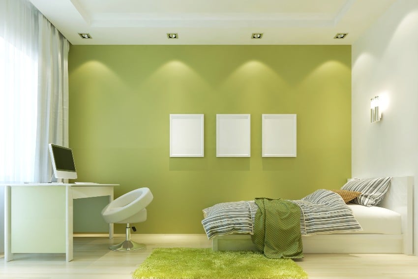 Contemporary white and lime green tone bedroom interior with a bed, accent chair and a desk 