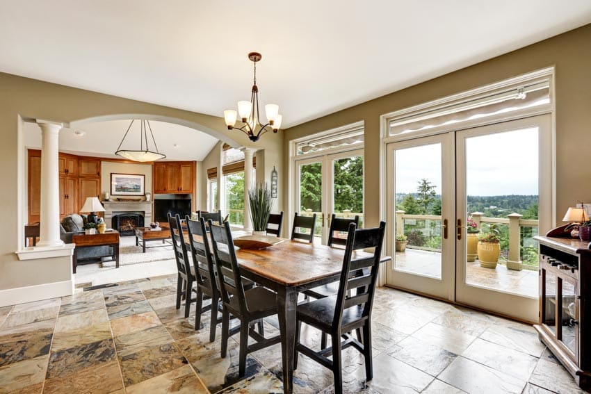 Dining room with glass doors, table, chairs, hanging light, and stone look vinyl flooring