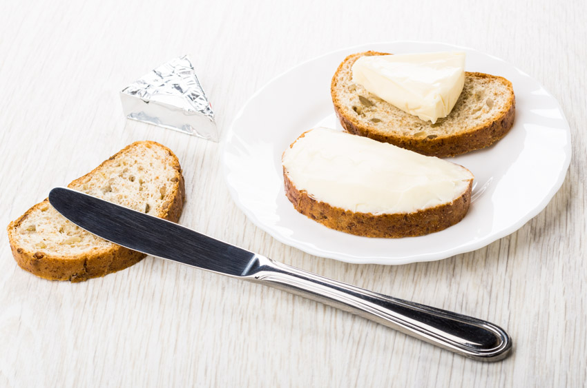 Dining surface with plate, butter, bread, and butter knife